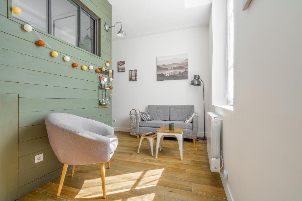 a living room with a couch and a chair at Le Petit Cocon - studio lit cabane, 10 min Compiègne in Le Meux