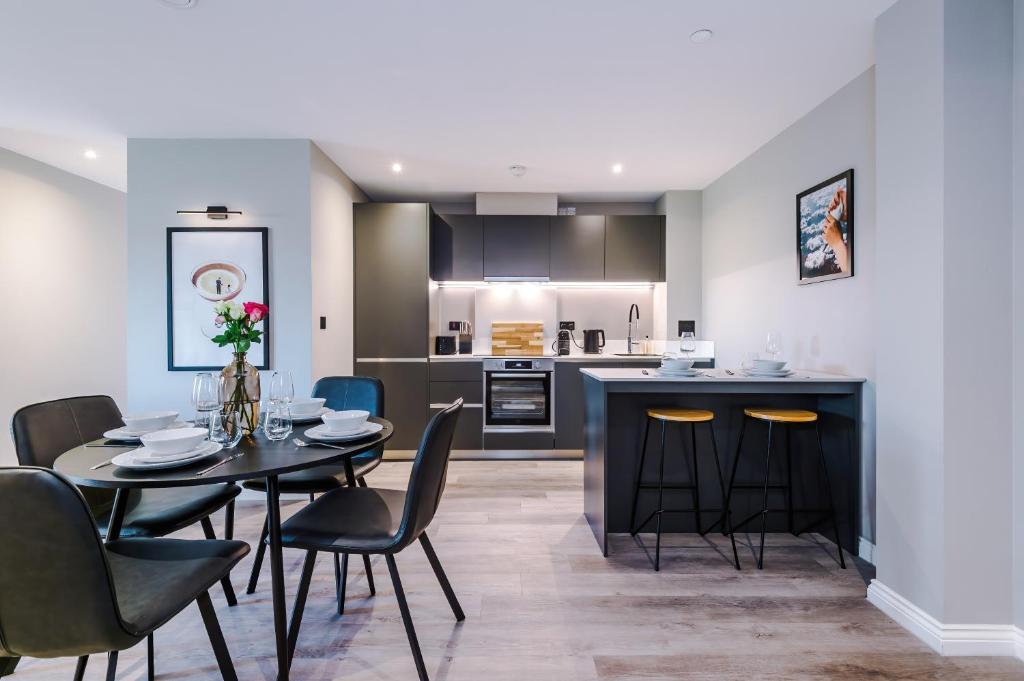 a kitchen and dining room with a table and chairs at Premium 3 Bed Apartment City Centre - Free Parking in Leeds