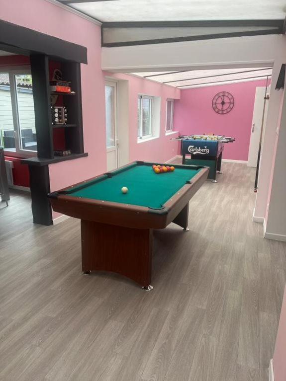 une pièce avec une table de billard et un mur rose dans l'établissement La casa di Vito, à Lallaing