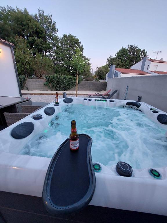 - un bain à remous avec une bouteille de bière dans l'établissement Agréable maison neuve avec spa, à Saint-Hilaire-de-Riez