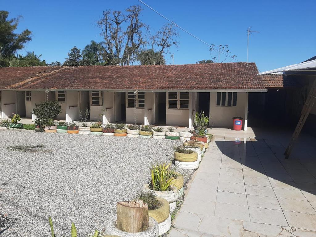 a house with potted plants in front of it at Vivendas do Trabalhador in São Francisco do Sul
