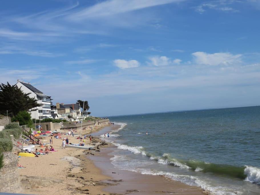 un groupe de personnes sur une plage près de l'océan dans l'établissement Apt T3, 2ch, tout à pied, 50m plage, Pointe du Bec, à Pornichet