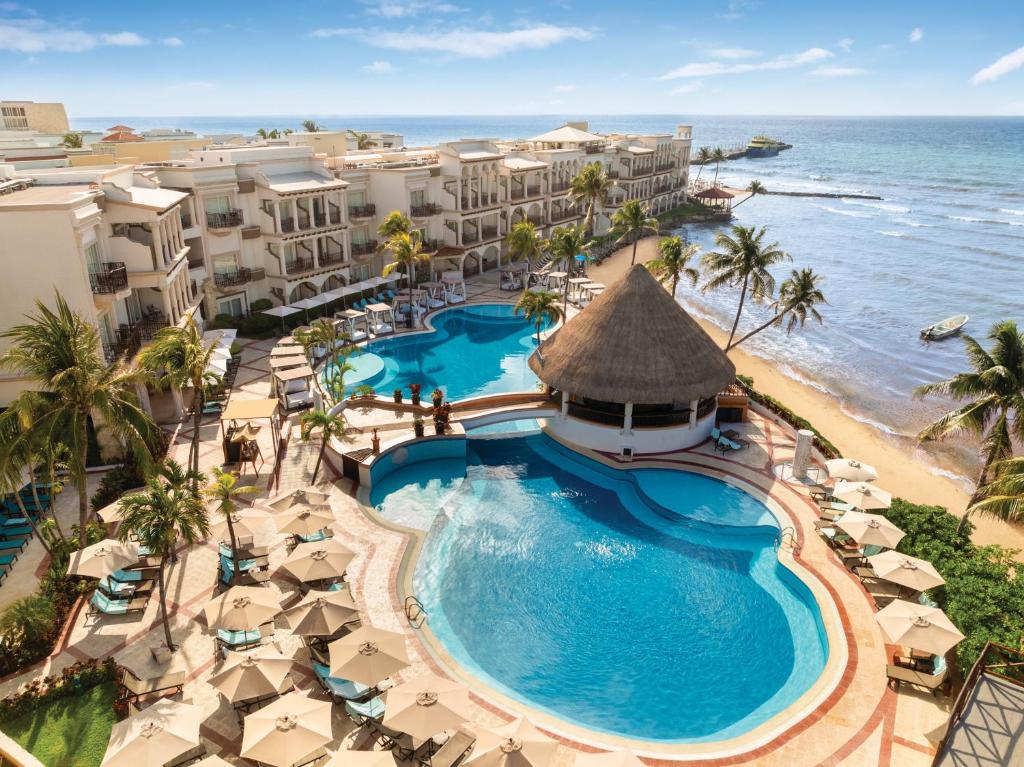une vue aérienne d'un complexe hôtelier avec piscine et l'océan dans l'établissement Wyndham Alltra Playa del Carmen Adults Only All Inclusive, à Playa del Carmen