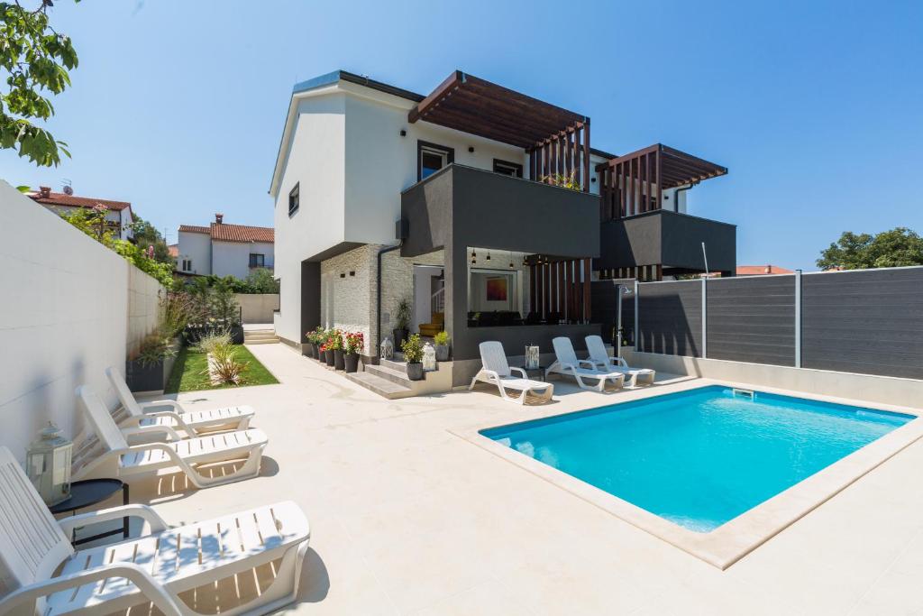 a villa with a swimming pool and lounge chairs at Villa Maša in Rovinj