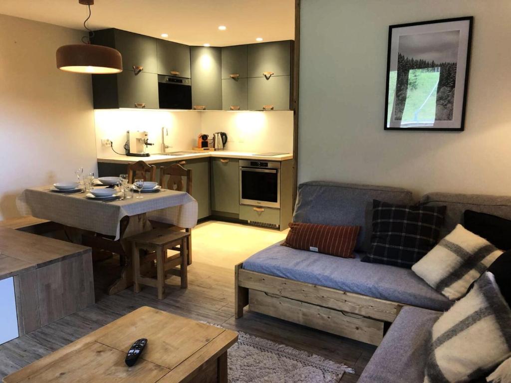 een woonkamer met een bank en een tafel en een keuken bij Résidence Lauziere Dessus - La Lauzière Dessus 22 - Crève Coeur MAE-4544 in Valmorel