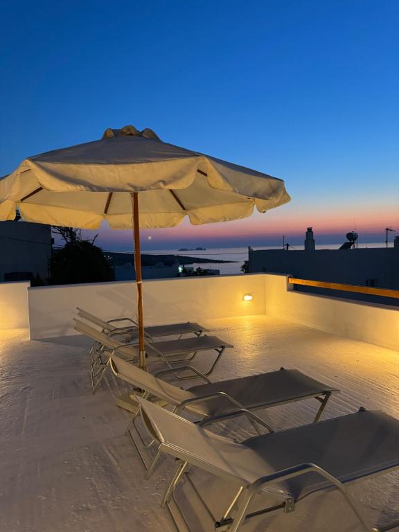 a couple of chairs and an umbrella on a patio at Marielen House in Kampos Paros