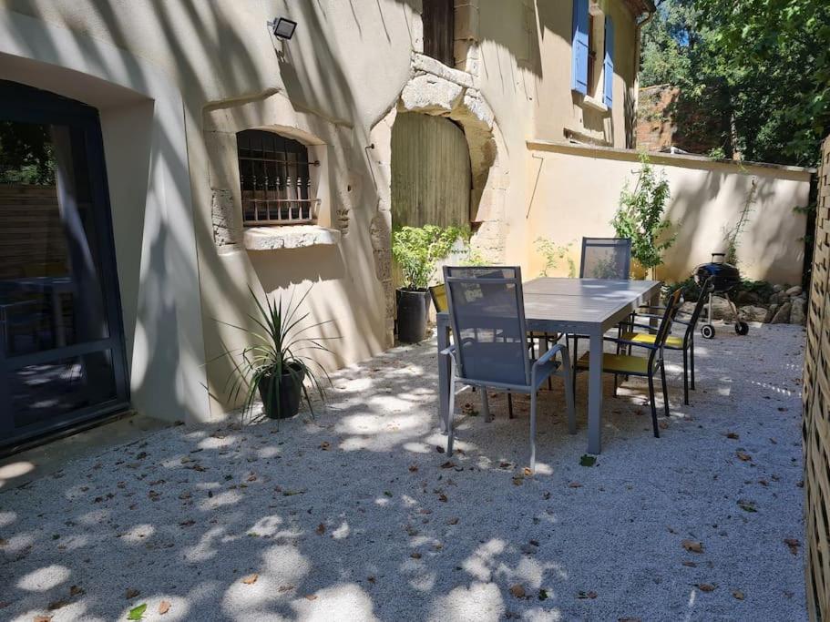 une table et des chaises assises à l'extérieur d'un bâtiment dans l'établissement Partie de mas en campagne, à Eyragues