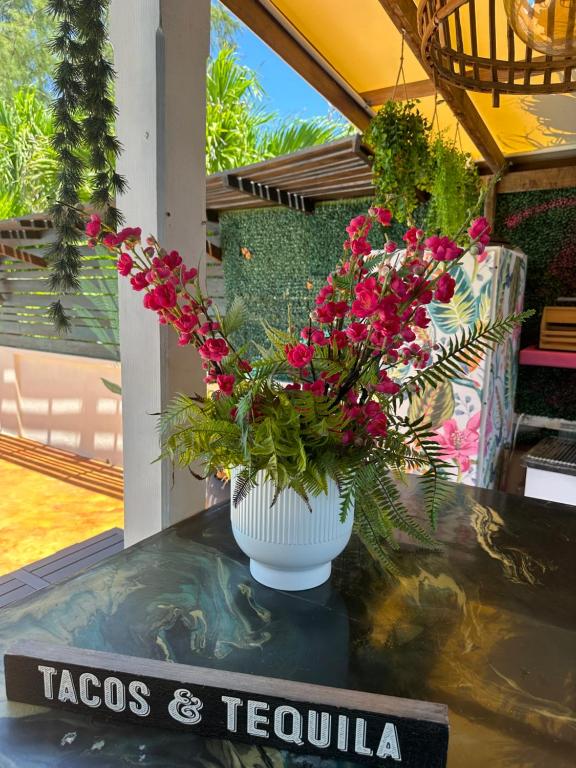 a vase filled with pink flowers on a table at Hidden Gem Barbados in Christ Church