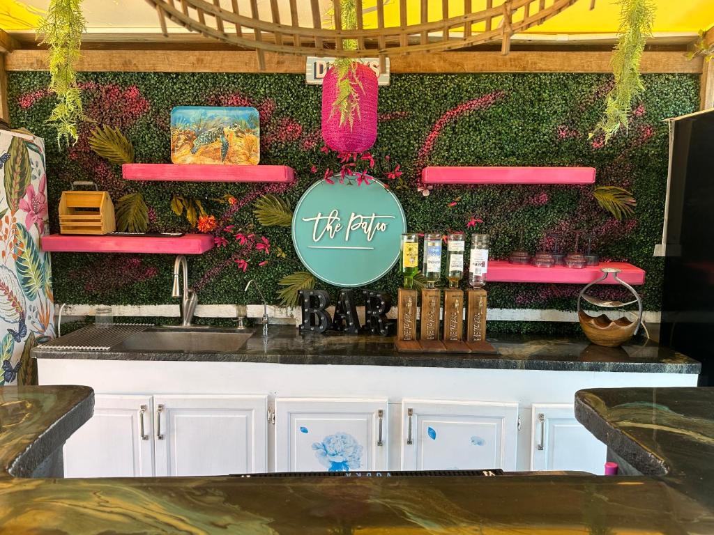 a bar in a restaurant with a wall of flowers at Hidden Gem Barbados in Christ Church