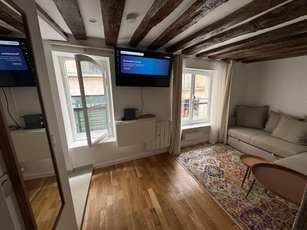 un salon avec un canapé et une télévision à écran plat dans l'établissement Studio Tout Équipé Bourse, à Paris