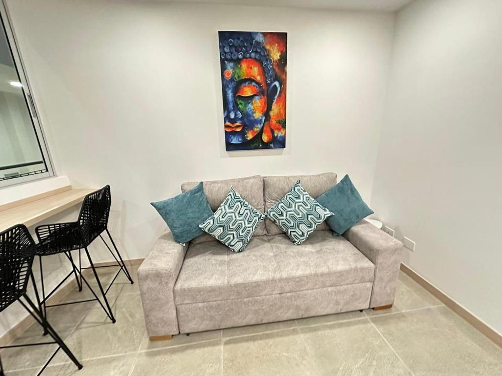 a couch in a living room with a painting at Belmonte403-Hermoso apartaestudio en avenida centenario in Armenia