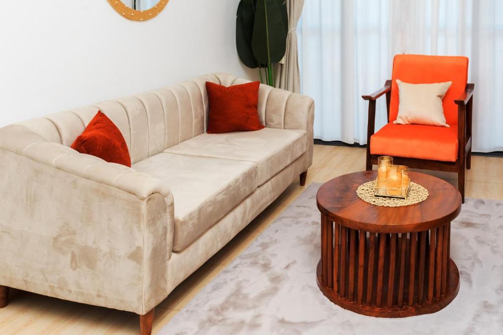 a living room with a couch and a table at Cozy Luxe Apartment in Wakiso