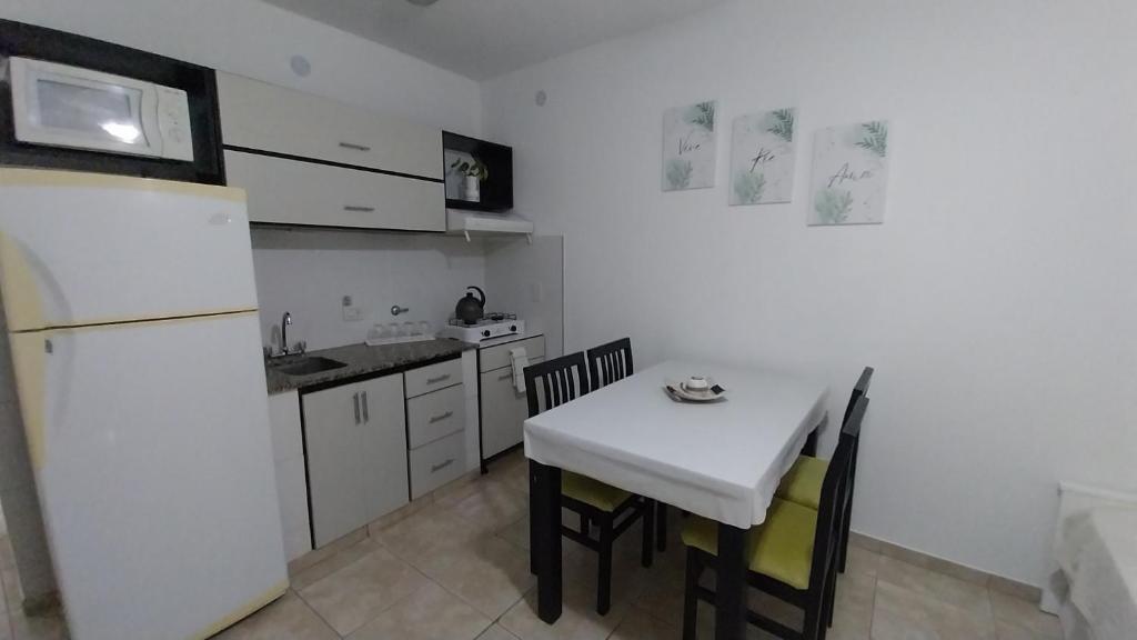 a kitchen with a white table and a white refrigerator at Departamento Marusa in Gualeguaychú
