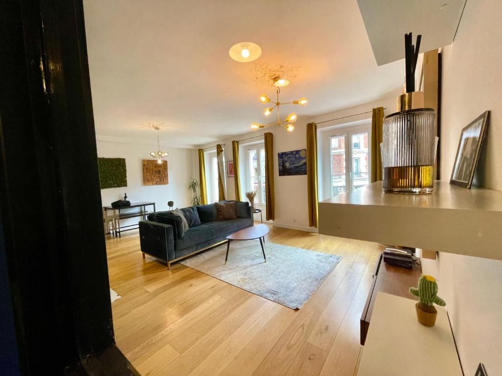 un salon avec un canapé et une table dans l'établissement Appartement Élégant & Chic à Paris, à Paris