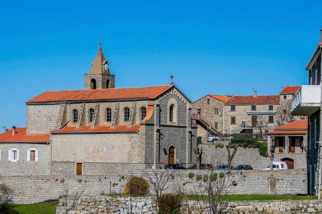 Une ancienne église en pierre avec une cloche au-dessus dans l'établissement Location de vacances, à Casalabriva