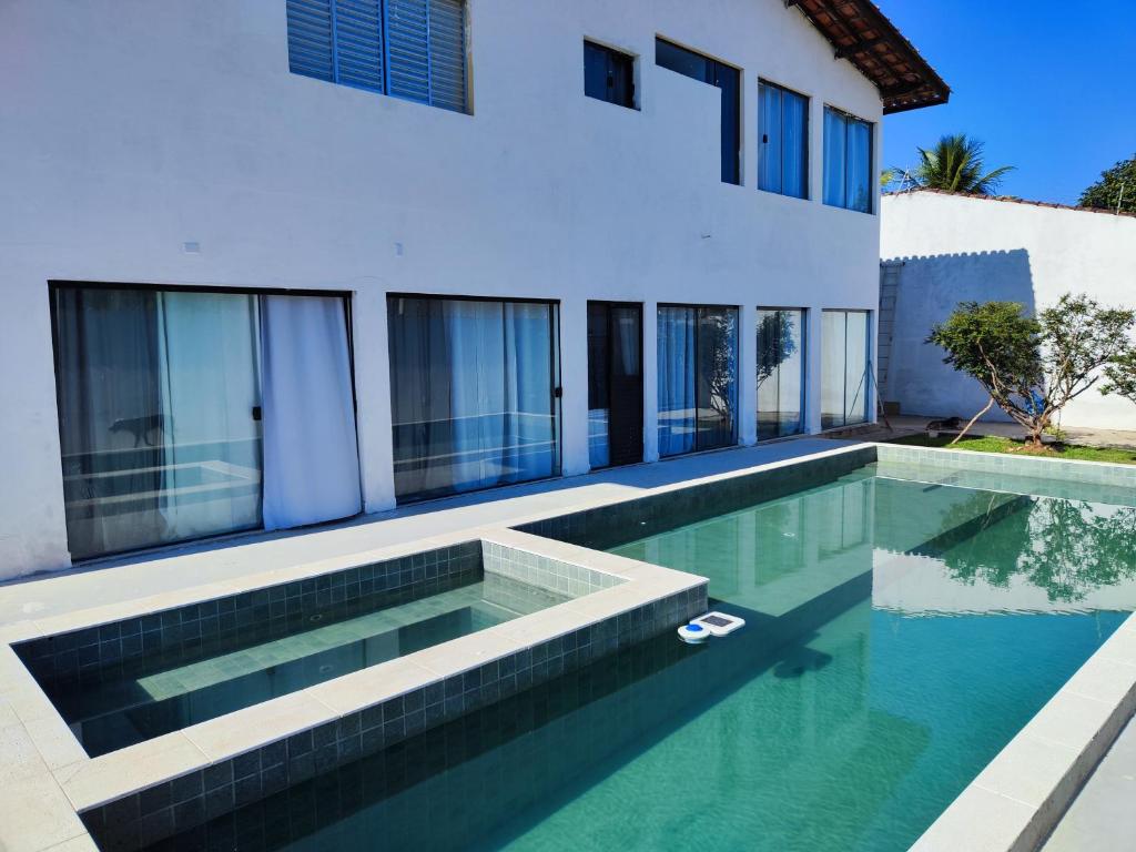 a swimming pool in front of a house at 11Suites casa Suite #3 in Caraguatatuba