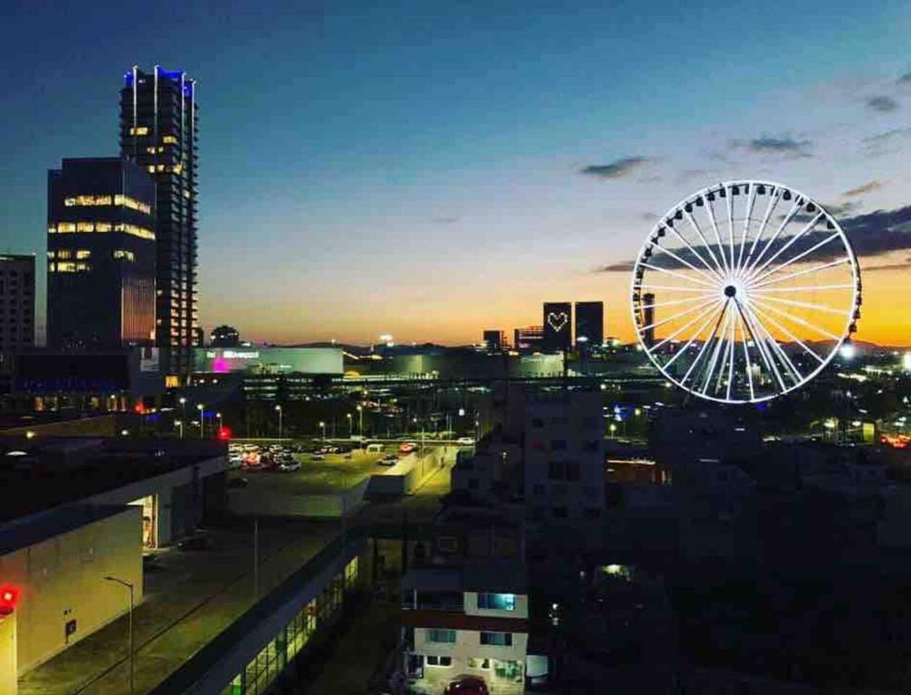 eine Skyline der Stadt mit einem Riesenrad in der Nacht in der Unterkunft NUEVO Penthouse para 8 en la Estrella de Puebla in El Gallinero