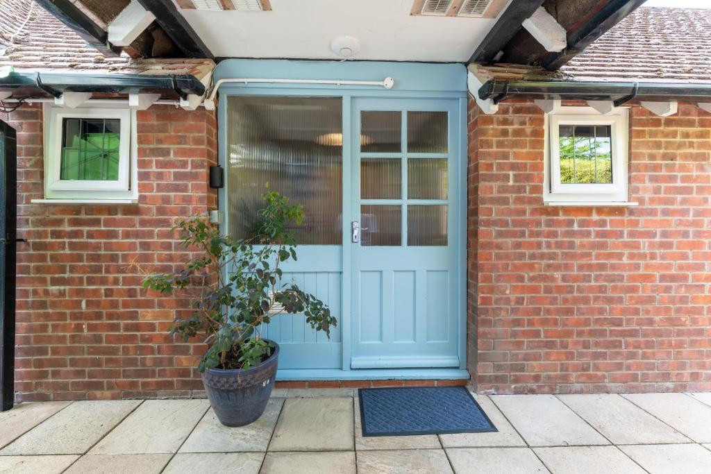 a blue front door of a brick house with a potted plant at Luxury En-Suite Room 2 in Blewbury Oxfordshire in Blewbury