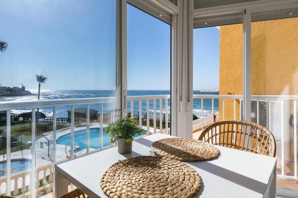 Un balcón con mesa y sillas y vista al mar. en @SeaFront, en Sitio de Calahonda