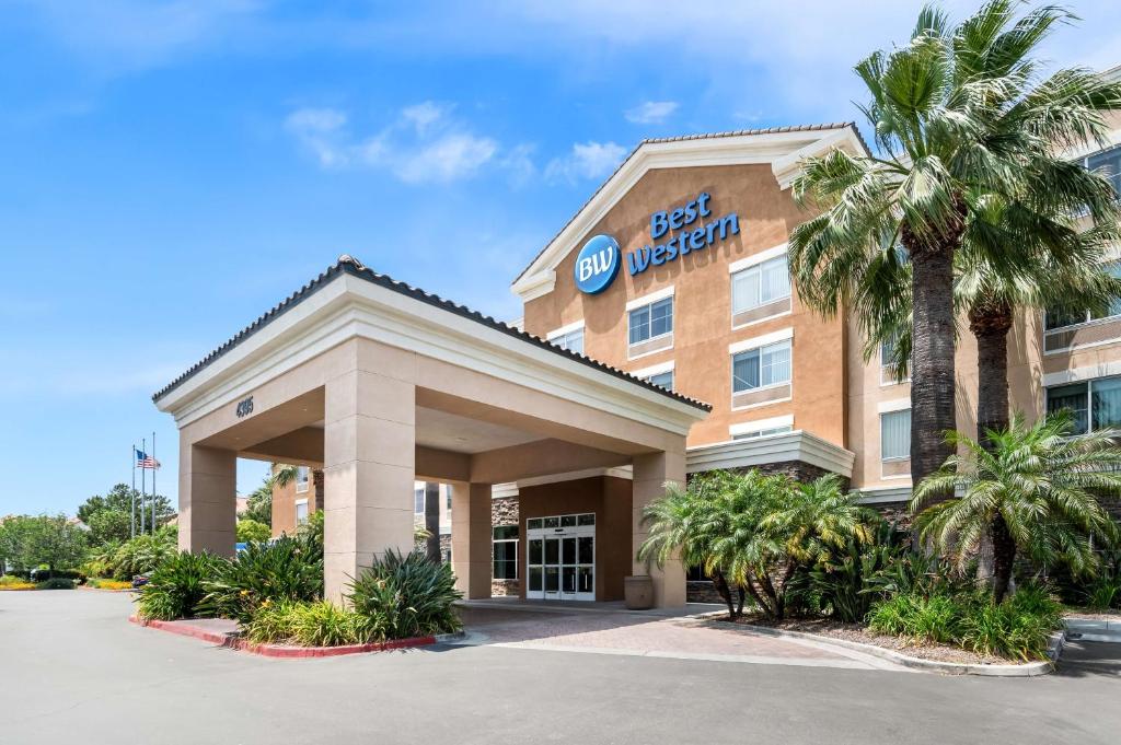 a front view of a hotel with palm trees at Best Western Ontario Mills Mall in Ontario