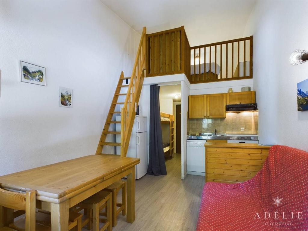 une petite cuisine avec une table en bois et un escalier dans l'établissement Studio mezzanine rénové 26m², au pied des pistes, balcon, 4 pers, proche commerces et garderie - FR-1-398-497, à La Rosière