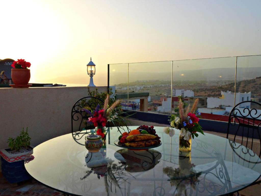 a table with a plate of food on top of a balcony at Paradise House Apartment in Tamraght in Tamraght Ouzdar