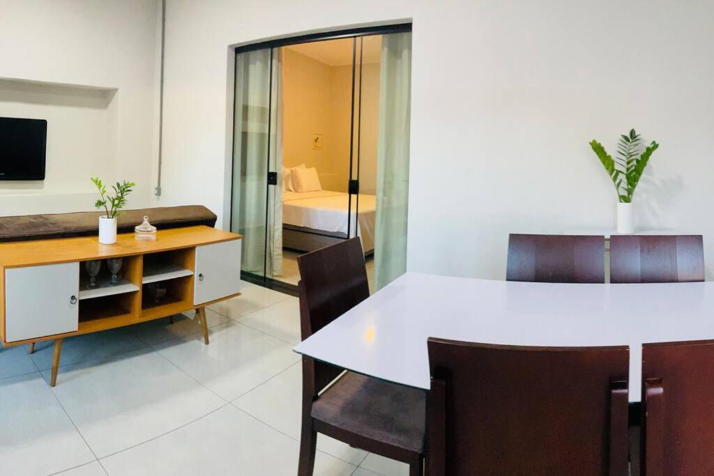 a dining room with a white table and chairs at Localizaçao privilegiada centro in Delfinópolis