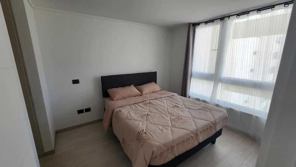 Un dormitorio con una cama y una ventana grande. en Laguna del mar, La Serena, en La Serena