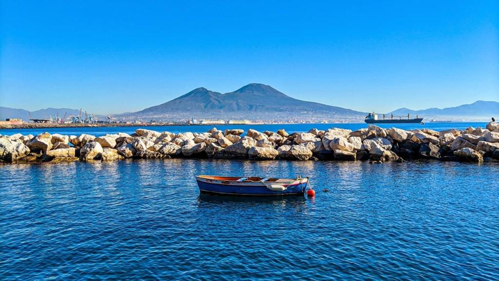 a small boat in the water next to some rocks at Casa Planzio in Naples