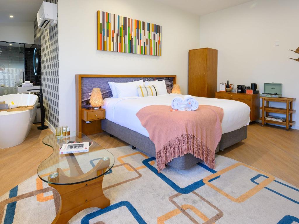 a bedroom with a bed and a glass table at Ohtel Auckland in Auckland