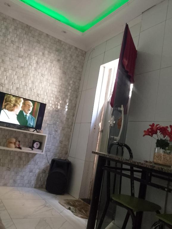 サルバドールにあるCasa de Clarissaの壁にテレビと椅子が置かれたバスルーム