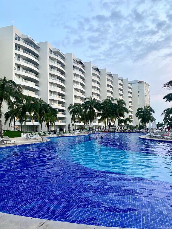 a large blue swimming pool in front of a hotel at Villa Magna in Nuevo Vallarta