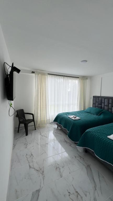 VillamaríaHospedaje Los Termales的卧室里有两张床和一台电视