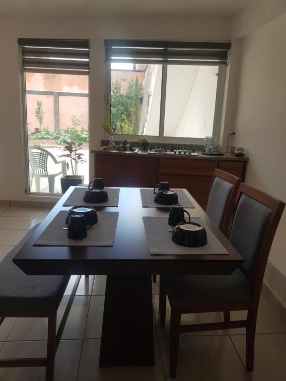 une salle à manger avec une table et des chaises en bois dans l'établissement Departamento los Pinos, à Zurumútaro
