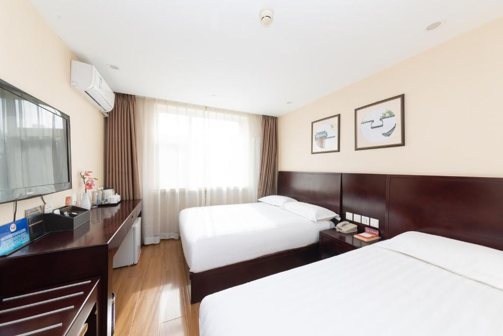 Postel nebo postele na pokoji v ubytování Golden Inns Chain Hotel Beijing JianGuomen 金泰之家北京站店