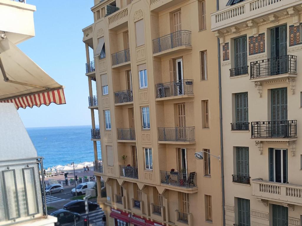 un grand immeuble avec des balcons à côté de l'océan dans l'établissement Nice promenade des anglais, à Nice