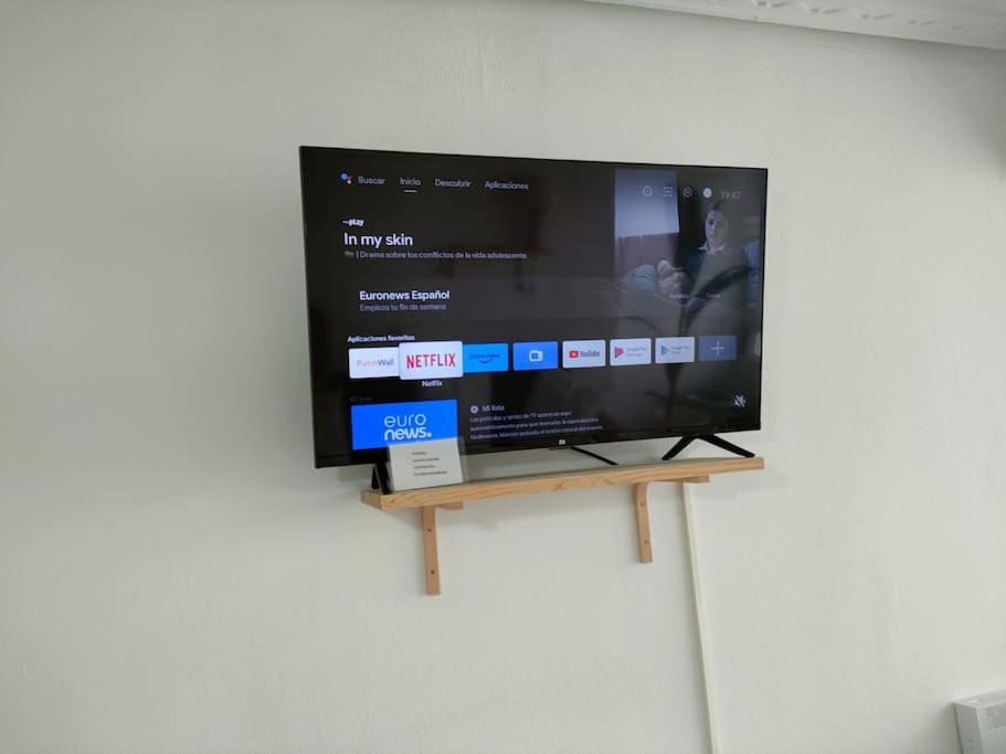 a flat screen tv on a stand on a wall at APARTAMENTO con ESTILO en el CENTRO -Stylish Apartment in the Center in Santander