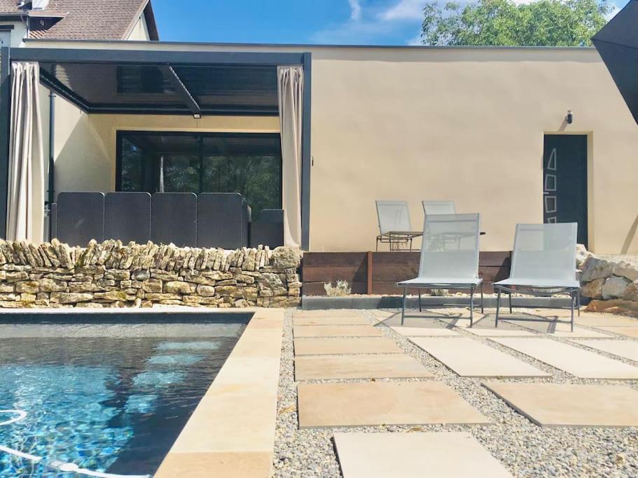 un patio avec deux chaises et une piscine dans l'établissement La Maison de la Mare, à Prenois