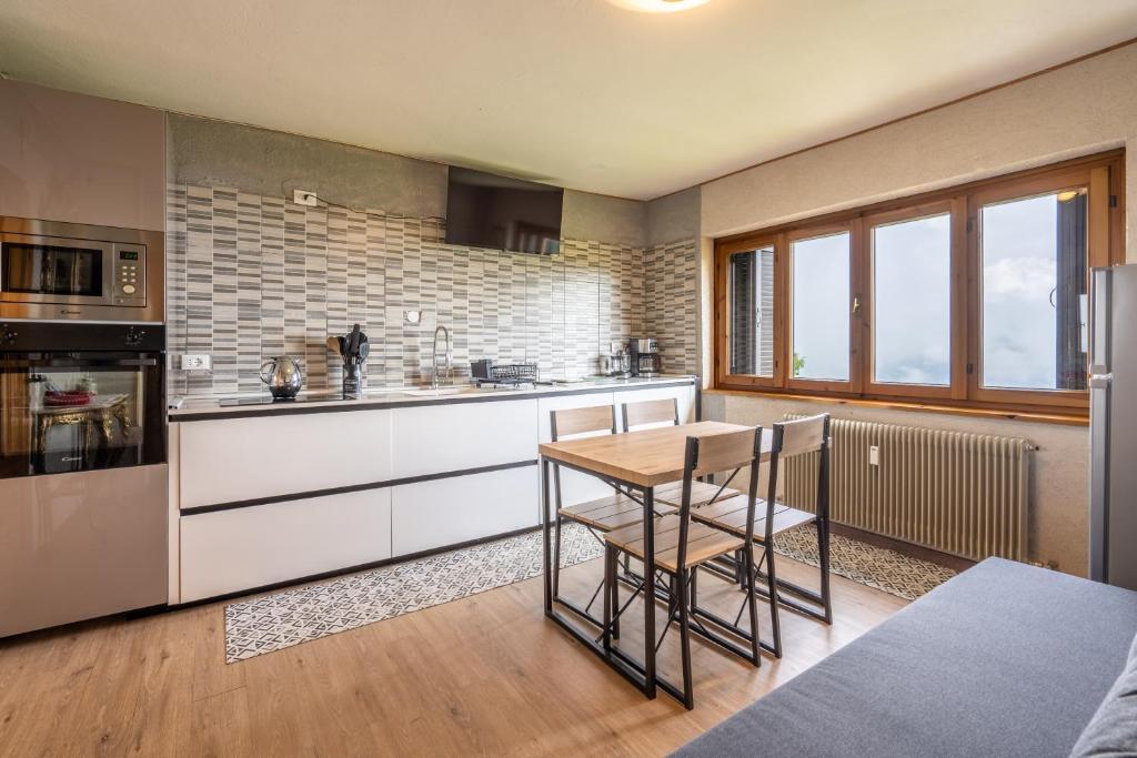 a kitchen with a wooden table and a counter at Appartamento Milollo Polsa in Brentonico