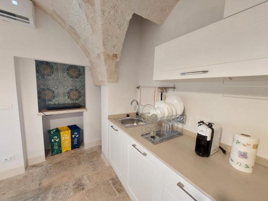 La cuisine est équipée de placards blancs, d'un évier et d'un comptoir. dans l'établissement Corso Perrini, 68, à Fasano
