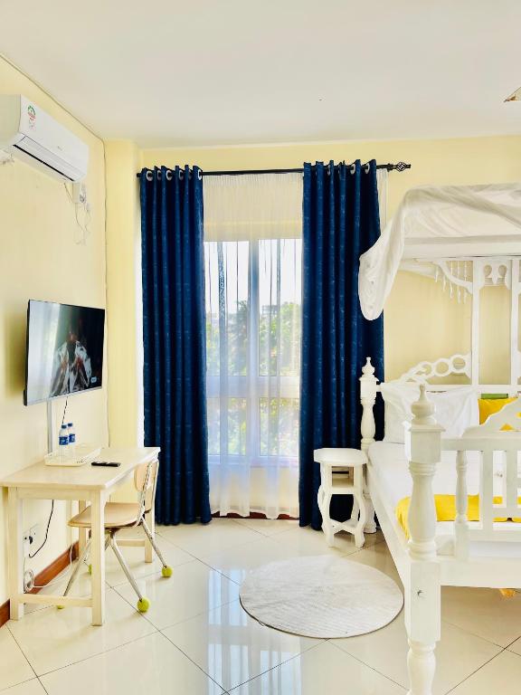 TV a/nebo společenská místnost v ubytování Elna's Nyali - Work & Unwind - Pool, Sea Views, AC & Fast Wi-Fi