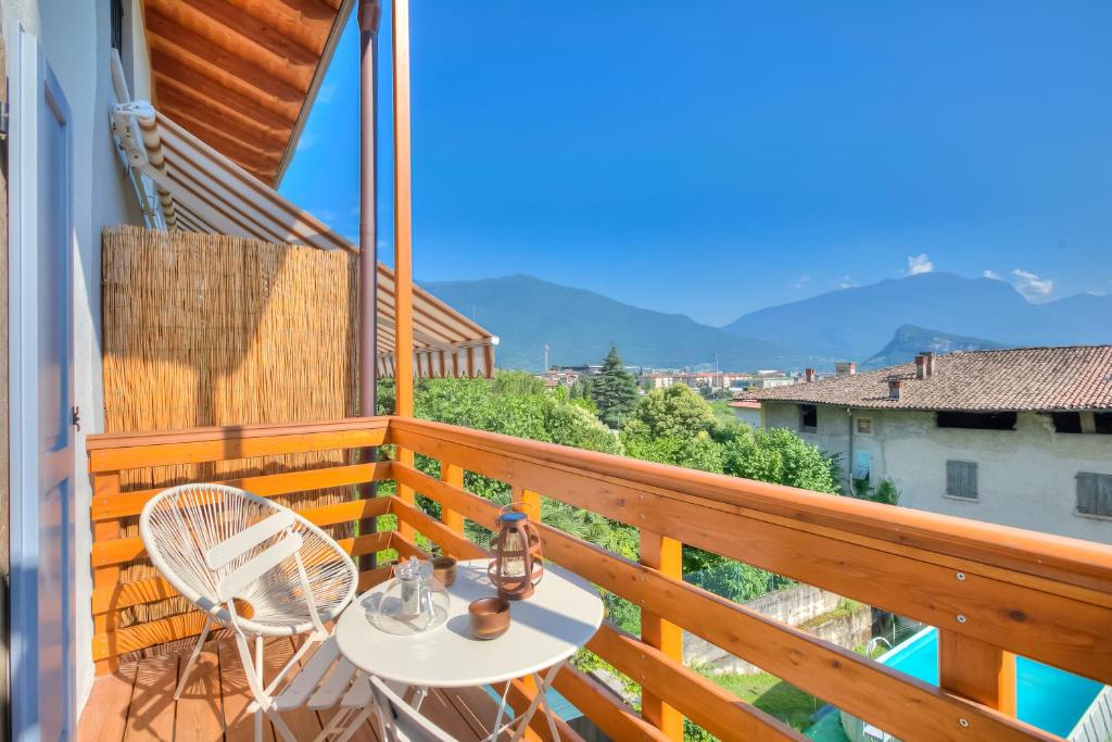 balcone con tavolo, sedie e montagne di Al Mandorlo Family & Bike Friendly - Happy Rentals ad Arco
