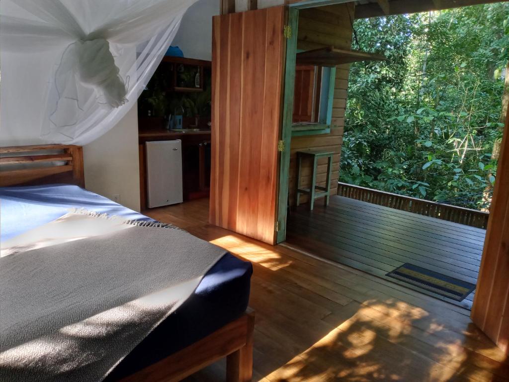 una camera da letto con un letto e una grande finestra di Jungle Paunch a Bocas del Toro