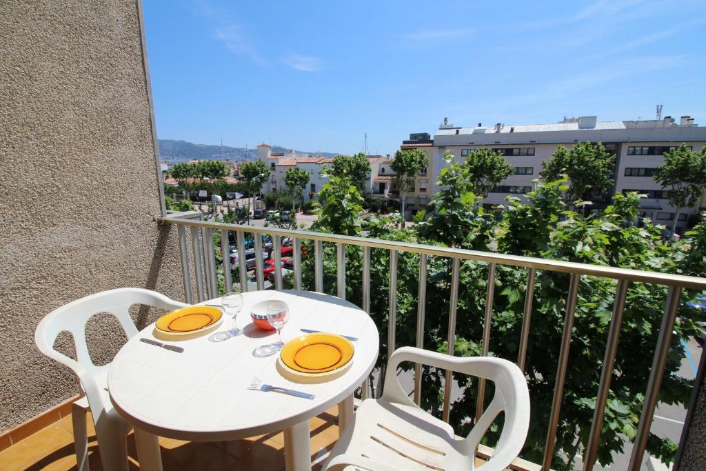 une table blanche et des chaises sur un balcon dans l'établissement Basic Comfort Studio POBLAT TIPIC 0168, à Empuriabrava