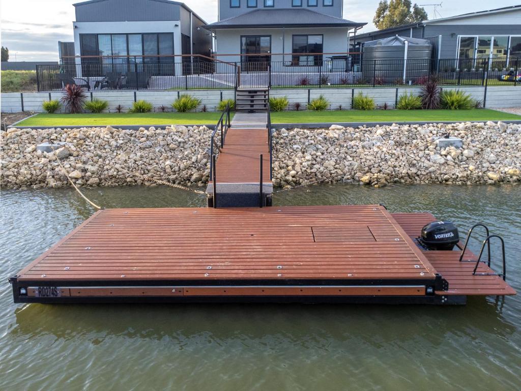 a dock in the water in front of a house at TheRiverbend43 Wellington Marina in Wellington East