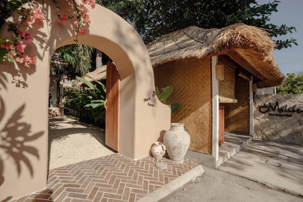 una piccola casa con un vaso accanto a un edificio di Melibe Dive Resort Bali a Tulamben