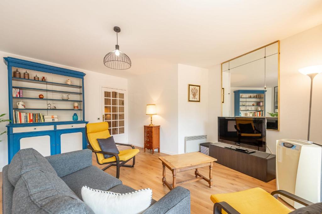 un salon avec un canapé et une télévision dans l'établissement LE Clos Saint-Michel, à Annecy