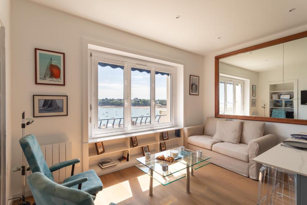 un salon avec un canapé et une fenêtre dans l'établissement Le Beauvoir 1 - Appt vue mer, à Dinard