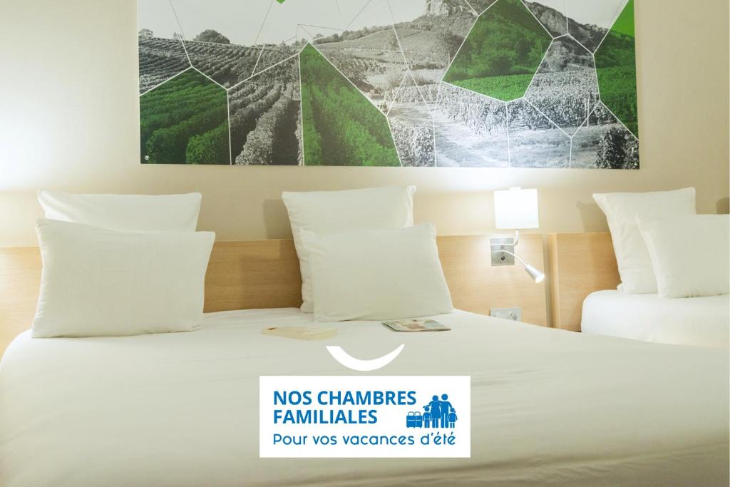 a hotel room with a bed with a sign on it at Brit Hotel M&acirc;con Centre Gare in M&acirc;con