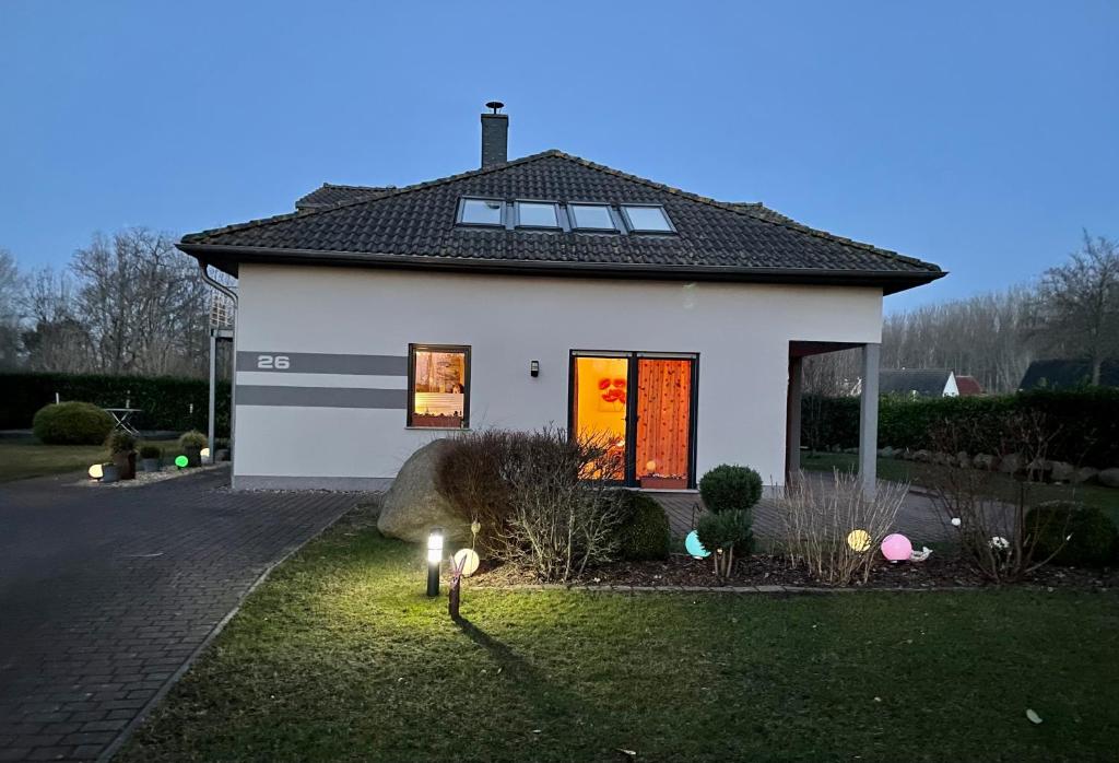 una casa bianca con luci nel cortile anteriore di Haus Amber Glowe a Glowe